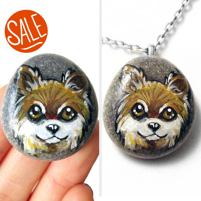a beach stone, wtih dog art: a painting of a brown and white long haired chihuahua, available as either a stone keepsake or a pendant necklace