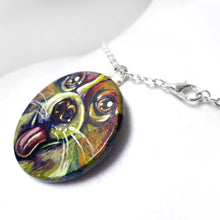 Load image into Gallery viewer, A circle wood pendant, hand painted with a portrait of a corgin in all the colours of the rainbow
