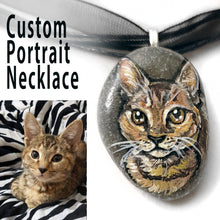 Load image into Gallery viewer, a small beach stone, hand painted with the portrait of a brown tabby cat, and made into a pendant necklace
