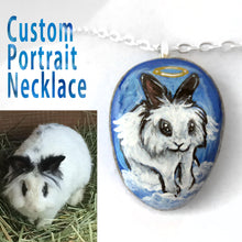 Load image into Gallery viewer, a custom art necklace, with a portrait of a white and black lionhead rabbit as an angel, painted on a beach stone
