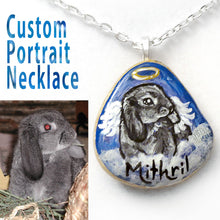 Load image into Gallery viewer, A custom pet portrait painting of a grey mini lop bunny rabbit, painted as an angel, on a small beach rock, crafted into a pendant necklace. 

