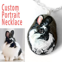 Load image into Gallery viewer, a personalized pet portrait of a black and white lionhead bunny rabbit, painted on a beach rock and handmade into a pendant necklace
