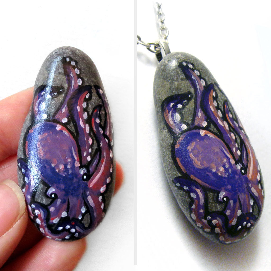 An oval shaped beach stone has been hand painted with a purple and pink octopus and is available as either a keepsake or a pendant necklace