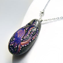 Load image into Gallery viewer, an oval beach rock has been painted with purple and pink octopus art and transformed into a pendant necklace
