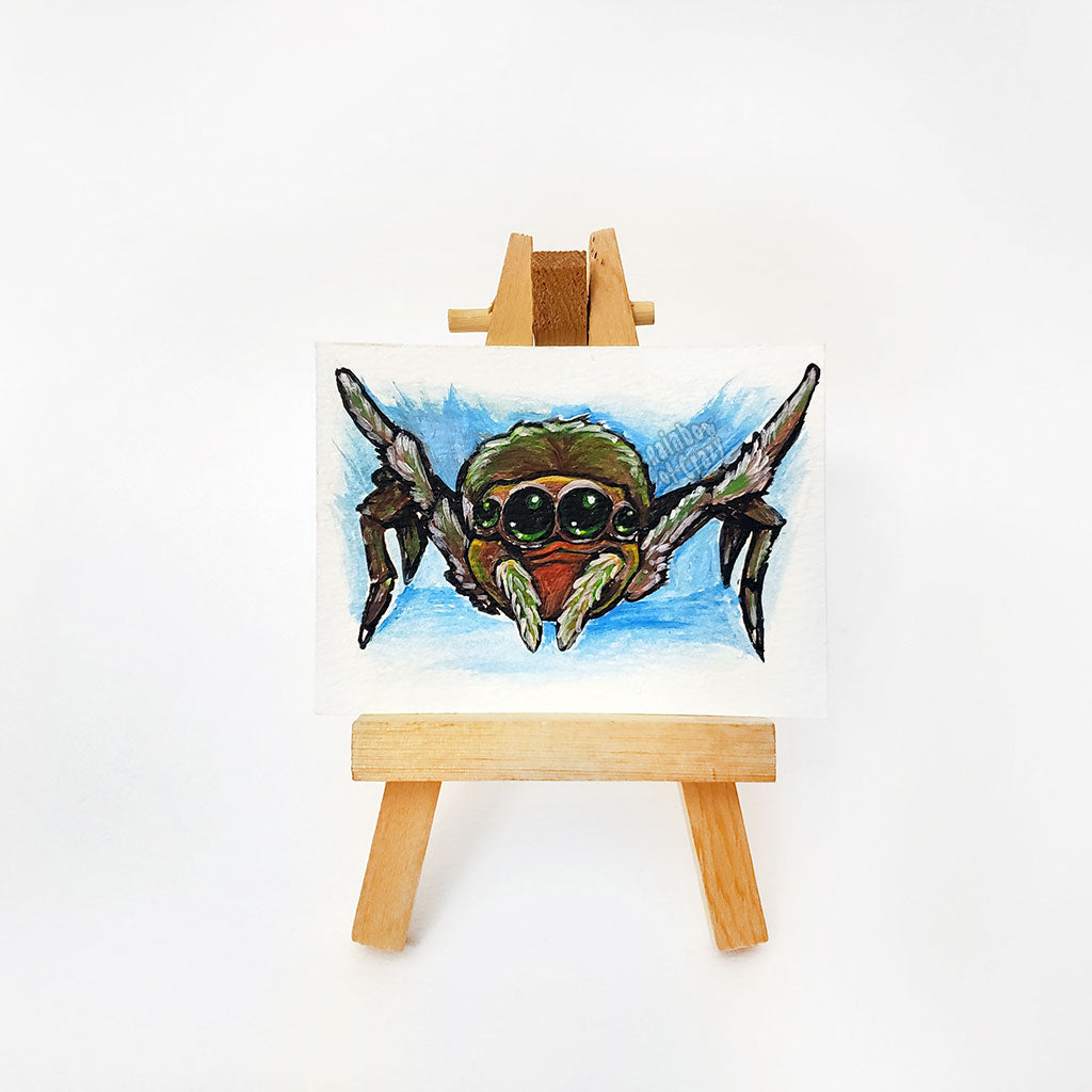 A small ACEO painting (2.5 inch by 3.5 inch) of a baby spider with large eyes, with front legs stretched out in happiness.