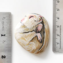 Load image into Gallery viewer, A small beach rock painted with a portrait of an albino ferret, next to two rulers, measures 1 7/8&quot; x 1 9/16&quot;.
