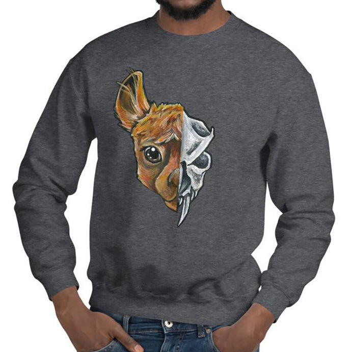 A man is wearing a unisex sweatshirt in the colour dark heather grey, printed with art split into two: the left side features the face of a brown alpaca, and the right side features an evil looking alpaca skull.