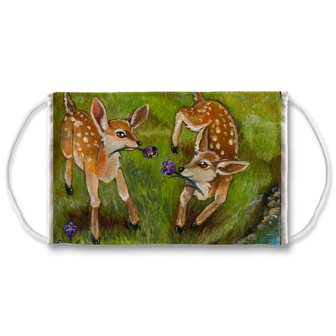 A reusable face mask, printed with art of two baby deer playing with flowers. Art from the Animism Tarot.