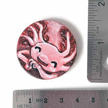 Load image into Gallery viewer, a smiling axolotl sleeping, hand painted on a circle wood disc, available as a keepsake or pendant necklace
