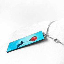 Load image into Gallery viewer, a wood rectangle hand painted with art of a black cat, with a red balloon, floating through a blue sky. available as a keepsake or pendant necklace
