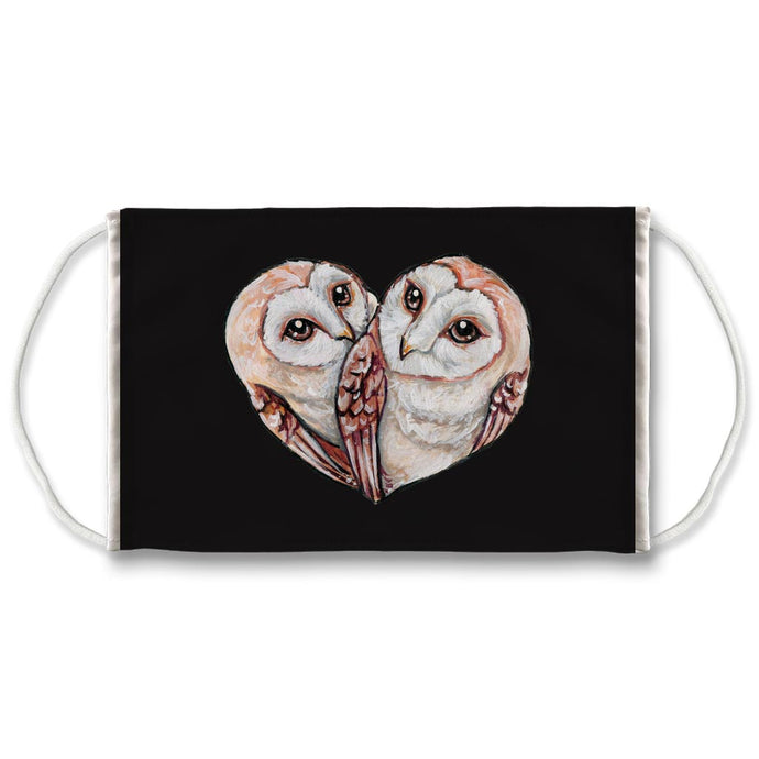 A black reuseabe face mask is printed with an illustration of two barn owls curled up together, forming the shape of a heart