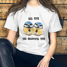 Load image into Gallery viewer, A woman wearing the Beautiful Tits Premium Unisex T-shirt in white with art of two blue tit birds, and the words, &quot;all tits are beautiful tits&quot;

