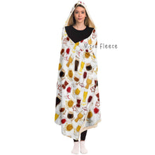 Load image into Gallery viewer, a woman wears the Beer Lovers Hooded Blanket, lined with microfiber fleece: a white hooded blanket printed with a variety of different beer styles in different glasses
