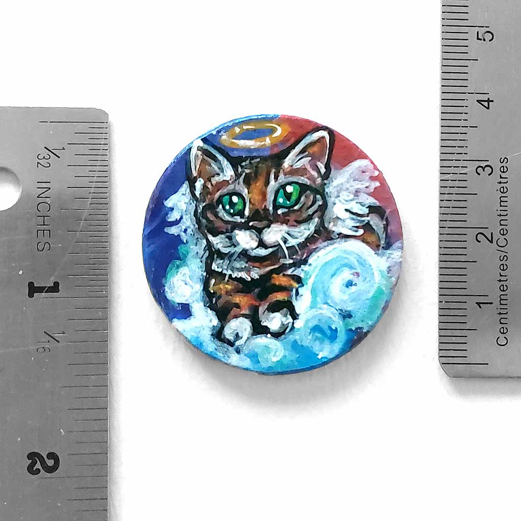 a small, wood circle, hand painted with a portrait of a Bengal cat as an angel resting on clouds