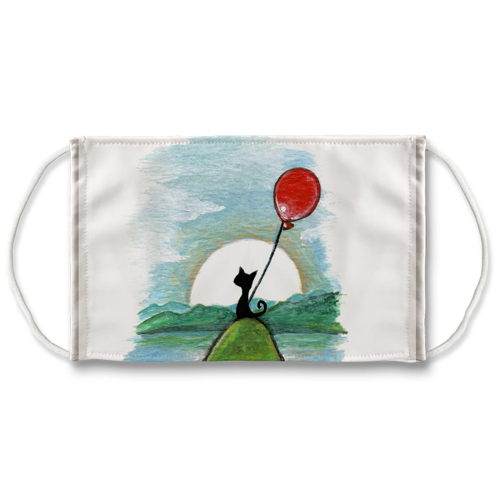 A reusable face mask features art of a black cat with a red balloon, standing on a hill in front of a sunrise.