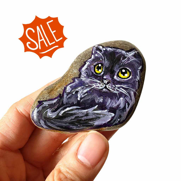small rock art, hand painted with art of a black persian cat with yellow eyes