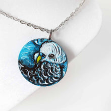 Load image into Gallery viewer, a small wood circle, hand painted with the portrait of a blue budgie bird, available as a keepsake or pendant necklace
