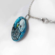 Load image into Gallery viewer, a small wood circle, hand painted with the portrait of a blue budgie bird, available as a keepsake or pendant necklace
