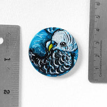 Load image into Gallery viewer, a small wood circle, hand painted with the portrait of a blue budgie bird, available as a keepsake or pendant necklace
