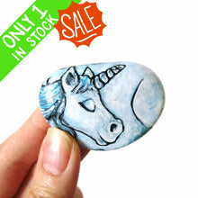 Load image into Gallery viewer, small rock art hand painted with the portrait of a light blue unicorn with its eyes closed 
