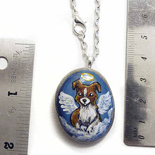 Load image into Gallery viewer, Small rock art of a border collie, painted as an angel, with halo and wings, sitting on clouds. available as a keepsake or pendant necklace
