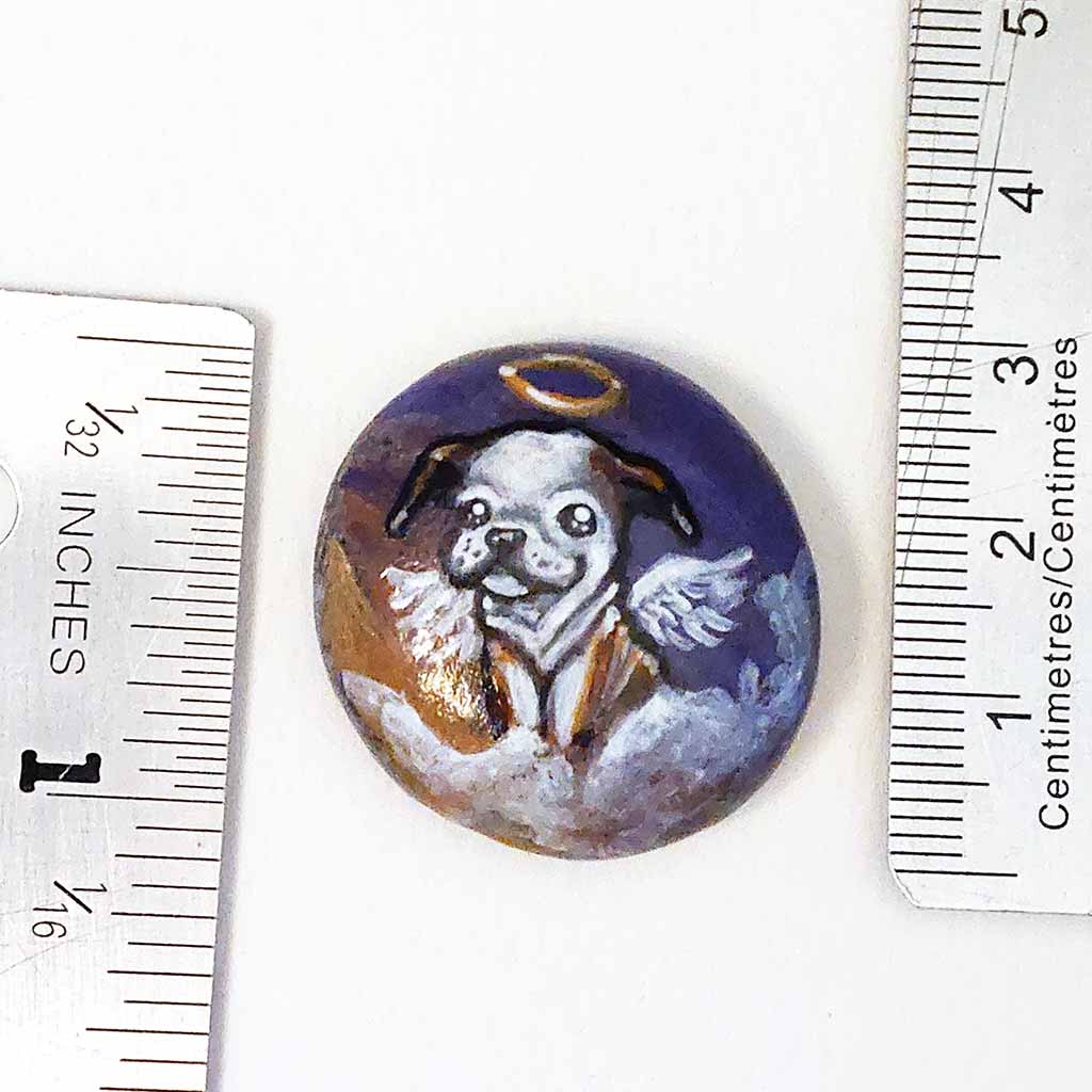 small rock art featuring a painting of an english bulldog painted as an angel in the clouds. available as a keepsake or necklacesmall rock art featuring a painting of an english bulldog painted as an angel in the clouds. available as a keepsake or necklace
