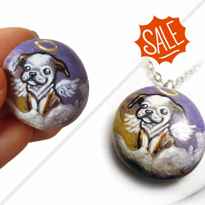 small rock art featuring a painting of an english bulldog painted as an angel in the clouds. available as a keepsake or necklace