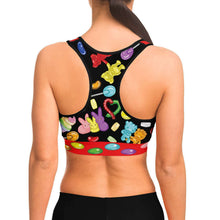 Load image into Gallery viewer, A woman wearing the Candy Lovers Sports Bra, featuring art of different rainbow candy.
