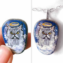 Load image into Gallery viewer, a small beach stone hand painted with the portrait of a grey Persian cat, as an angel on the clouds. available as a keepsake or pendant necklace
