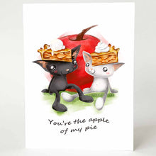 Load image into Gallery viewer, a greeting card with art of a black cat and white cat, both wearing slices of apple pie on their heads. they sit in front of a giant apple. card reads, you&#39;re the apple of my pie
