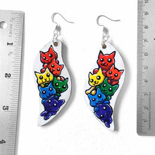 Load image into Gallery viewer, wavy, leaf shaped, wood earrings, hand painted with six cats in every colour of the rainbow, against a white background
