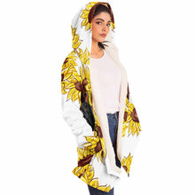 Load image into Gallery viewer, a woman wears a white microfiber fleece cloak (with pockets), printed with sunflower art, with a black cat and white cat peeking out from the flowers
