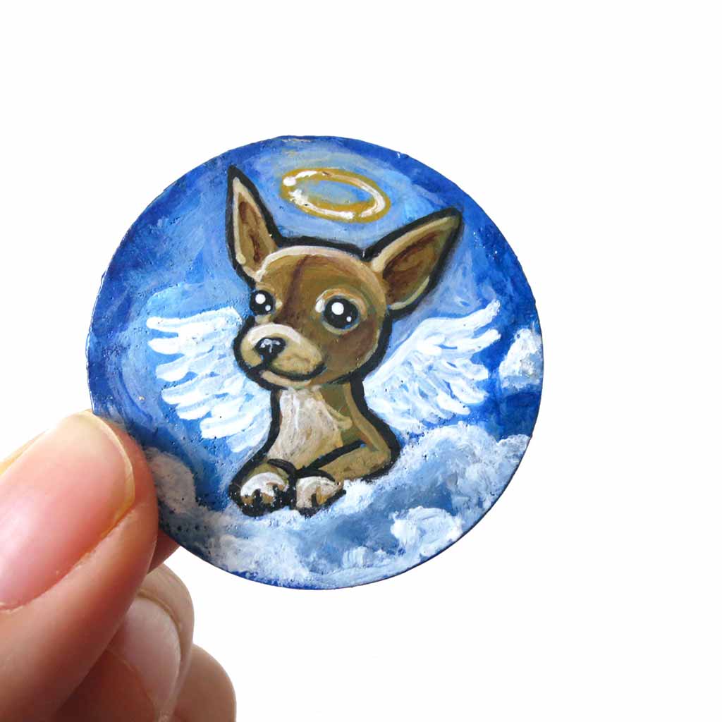 a small lightweight wood circle, hand painted with the portrait of a chihuahua as an angel in the clouds. available as a keepsake or pendant necklace