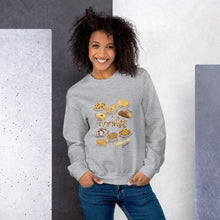 Load image into Gallery viewer, A woman wearing the Cookie Lovers Unisex Sweatshirt in the colour sport grey, which features an image of 10 types of cookies
