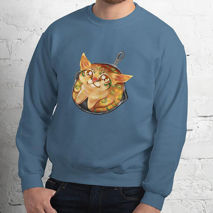 A man is wearing a unisex sweatshirt in the colour indigo blue, featuring art of a cornbread cat with jalapenos, sitting in a cast iron pan.