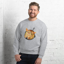 Load image into Gallery viewer, A man is wearing a unisex sweatshirt in the colour sport grey, featuring an illustration of a cornbread cat with jalapenos, sitting in a cast iron pan.
