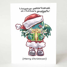 Load image into Gallery viewer, a greeting card with an illustration of a Cthulhu dressed as Santa Claus, holding a gift. The card reads,  &quot;Lloigehye yah&#39;or&#39;nanah ot r&#39;luhhor&#39;s gnaiigof&#39;n!&quot; above and &quot;[Merry Christmas!]&quot; below
