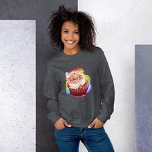 Load image into Gallery viewer, A woman wears a unisex sweatshirt in the colour heather grey, featuring artwork of a cat painted as a red velvet cupcake with rainbow sprinkles.
