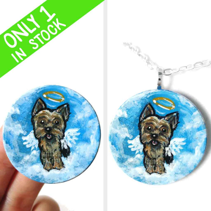 a lightweight wood disc, hand painted with the portrait of a yorkshire terrier as an angel, available as a keepsake or pendant necklace