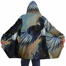 Load image into Gallery viewer, a man wearing a navy blue and orange cloak, featuring art from the Eight of Cups card, from the Animism Tarot: a magpie, with wings spread, flies up into the night sky.
