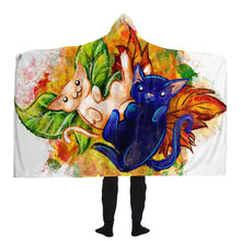 Load image into Gallery viewer, a man is wearing the Autumn Fairy Cats Hooded Blanket, featuring art of a white/orange cat, and black/blue cat, each with leaf wings
