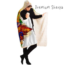 Load image into Gallery viewer, a man is wearing the Autumn Fairy Cats Hooded Blanket with premium sherpa lining, featuring art of a white/orange  cat, and black/blue cat, each with leaf wings
