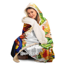 Load image into Gallery viewer, a woman is wearing the Autumn Fairy Cats Hooded Blanket with microfleece lining, featuring art of a white/orange  cat, and black/blue cat, each with leaf wings
