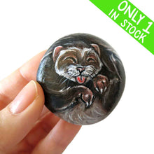 Load image into Gallery viewer, a small beach stone, hand painted with a portrait of a smiling ferret with its tongue out
