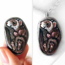 Load image into Gallery viewer, a small beach stone, hand painted with a portrait of a smiling ferret, available as a keepsake rock art, or pendant necklace
