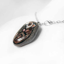 Load image into Gallery viewer, a small beach stone, hand painted with a portrait of a smiling ferret, available as a keepsake rock art, or pendant necklace
