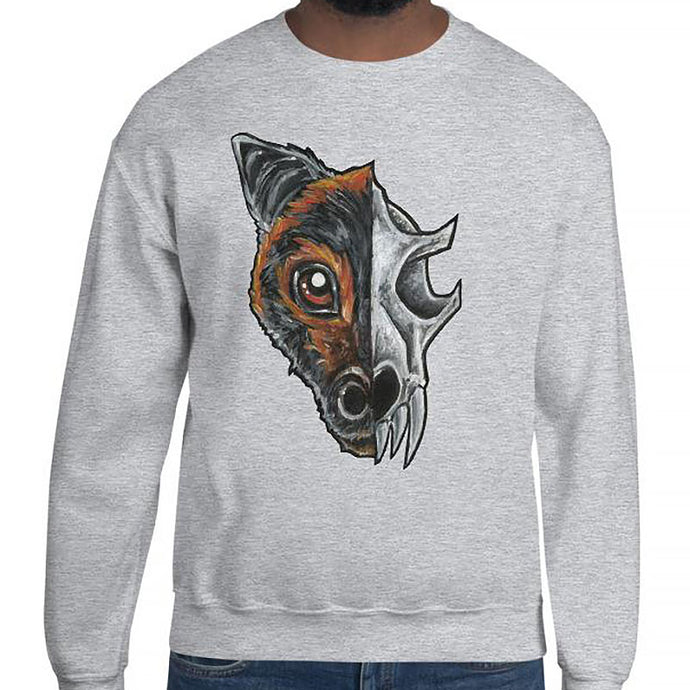 A man is wearing a unisex sweatshirt in the colour sport grey, which is printed with a split illustration: the left side features the face of a flying fox bat, and the right side features an evil looking bat skull