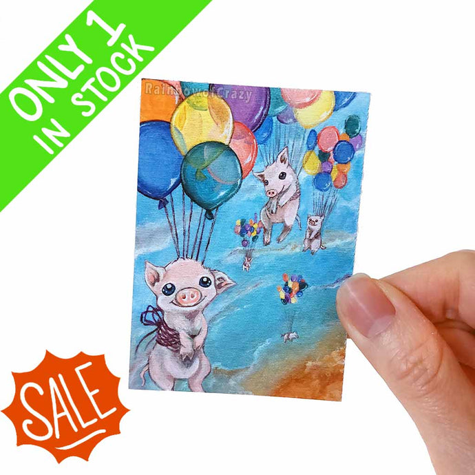 this aceo print features art of 5 baby flying pigs floating while attached to many rainbow balloons