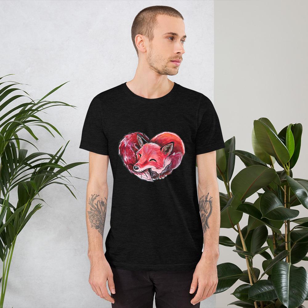A man is wearing the Fox Love Premium Unisex T-shirt in the colour black heather, which includes art of a red fox sleeping in the shape of a heart.