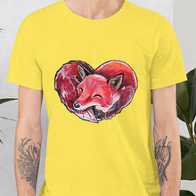 Load image into Gallery viewer, A man is wearing the Fox Love Premium Unisex T-shirt in the colour yellow, which includes a print of a red fox sleeping in the shape of a heart.
